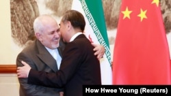 Chinese Foreign Minister Wang Yi (right) greets Iranian Foreign Minister Mohammad Javad Zarif at the Diaoyutai State Guesthouse in Beijing on August 26, 2019.
