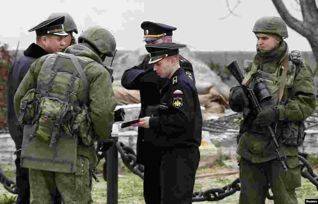 Ukraine -- Armed men, believed to be Russian servicemen, check documents of Russian navy officers who enter the territory of the naval headquarters in Sevastopol, March 19, 2014