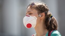 Женщина в маске на улице в Киеве. 27 июня 2020 года.