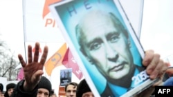 A protester holds up a picture of Vladimir Putin with the "No!" across it. As one observer notes, if the rallies are really about Putin's return to the presidency, they will only grow.