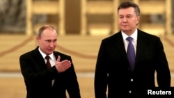 Russian President Vladimir Putin (left) gestures to guide Ukrainian President Viktor Yanukovych toward a meeting of the Russian-Ukrainian Interstate Commission at the Kremlin in Moscow in December.