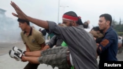 Мұхаммед Мурсиді жақтайтындар наразылық акциясы кезінде жараланған адамды көтеріп бара жатыр. Наср, 27 шілде 2013 жыл.