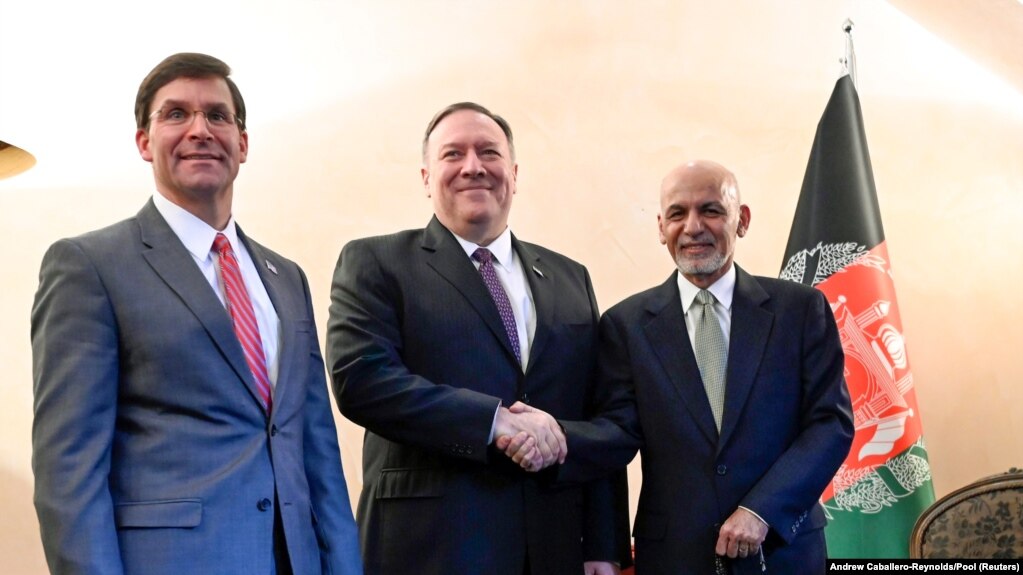 U.S. Secretary of State Mike Pompeo (center) shakes hands with Afghan President Ashraf Ghani as U.S. Secretary of Defense Mark Esper looks on at the Munich Security Conference on February 14. 