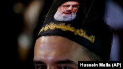 LEBANOn -- A Lebanese Shiite supporter of the Iranian-backed Hizballah group, with a portrait on his head of Hizballah leader Sayyed Hassan Nasrallah, attends an activities to mark the ninth of Ashura, a 10-day ritual commemorating the death of Imam Husse