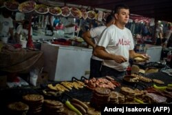 Мужчина продает мясо на гриле во время традиционной общественной ярмарки в Сабаче, 100 км от Белграда