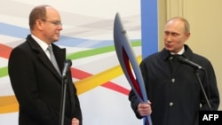 Russian President Vladimir Putin (right) hands over an Olympic torch to Prince Albert II of Monaco as a present for his private collection of Olympic torches. 