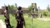 FILE: An anti-Taliban militia fighters look at the Afghan policemen as they prepare to battle the Taliban.