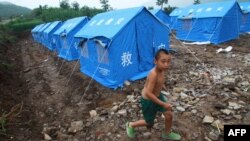 Мальчик играет возле палаток, которые установлены в качестве временного жилья. Иллюстративное фото.