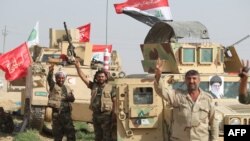 A picture of Iran's supreme leader Ayatollah Ali Khamenei (R) adorns a military vehicle as Iraqi security forces and paramilitaries deploy in al-Nibaie area, north-west of Baghdad, May 26, 2015