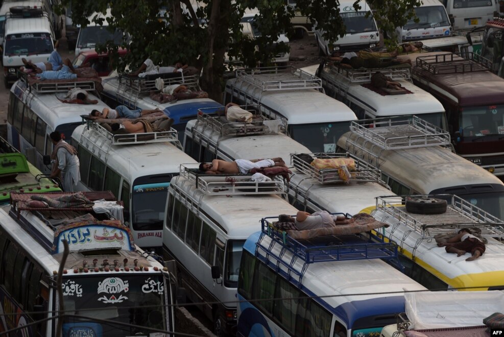 Pastrues pakistanez dhe shoferët e autobusëve duke fjetur mbi automjete, herët në mëngjes në Lahore.&nbsp;
