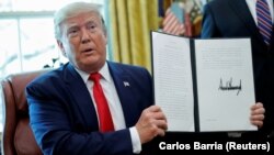 U.S. President Donald Trump displays an executive order imposing fresh sanctions on Iran in the Oval Office of the White House in Washington, June 24, 2019