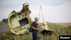 A Malaysian air crash investigator inspects the crash site of Malaysia Airlines Flight MH17, near the village of Hrabove on July 22.