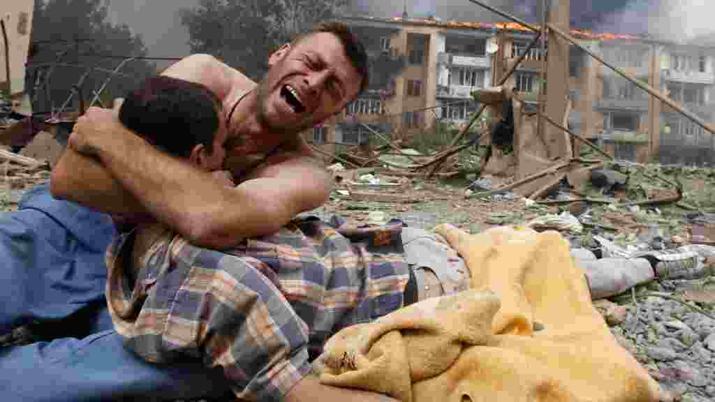 Грузин плачет, держа тело близкого человека, после российского бомбардировки 9 августа в Гори; Грузия, у административной границы с Южной Осетией