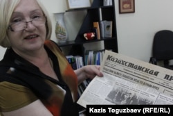 Тамара Калеева жұмыс істеген кезде ел президенті Нұрсұлтан Назарбаевпен бірге түскен сурет басылған "Казахстанская правда" газетін көрсетіп тұр. Алматы, 8 шілде, 2016 жыл (Азаттық ахивіндегі фото)