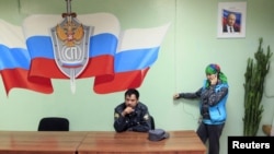 Орусиянын полиция бөлүмүндөгү мигрант аял