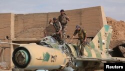 Syrian Democratic Forces (SDF) fighters on a damaged airplane inside Tabqa military airport after taking control of it from Islamic State fighters, west of Raqqa on April 9.