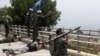 Lebanese soldiers take positions as UN peacekeepers gesture toward Israeli soldiers at the Lebanese-Israeli border in Adaisseh village in August 2010.