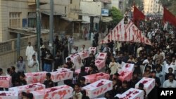 Pakistani Shi'a carry fake coffins through Karachi after the bomb blast that killed more than 40 people during the Ashura holiday on December 28.