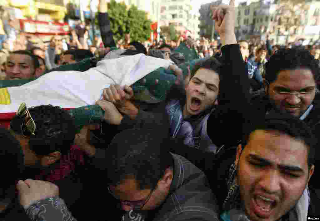 Protesters carry the body of a man killed during an attempt to storm the Interior Ministry in Cairo on January 29, 2011.