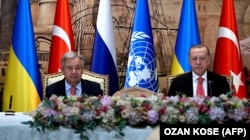 BM Baş kâtibi António Guterres (soldan) ve Türkiye prezidenti Recep Rayyip Erdoğan Ukrayına limanlarından zahire ihracatını bloktan çıqaruv añlaşması imzalanğanda. İstanbul, Türkiye, 2022 senesi iyülniñ 22-si