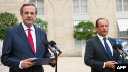 French President Francois Hollande (right) and Greek Prime Minister Antonis Samaras speaking to journalists in Paris on August 25.