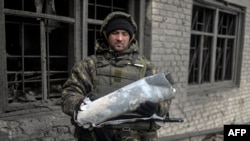 Український військовий демонструє фрагмент ракети після влучання в цивільний об’єкт у Дебальцеві, 29 січня 2015 року