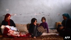 Syrian Kurdish refugees from the Sheikh Maqsud district of Aleppo sit at a school being used as a refugee camp in the northern, mostly Kurdish town of Afrin.