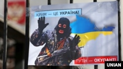 Плакат із зображенням президента Путіна як «зеленого чоловічка» на акції «Крим – це Україна» біля російського посольства у Києві 2020 року