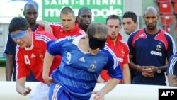 Члены национальной сборной Франции по футболу наблюдают за игрой команды французской Ассоциации слепых и слабовидящих футболистов (2 июня 2009 года).