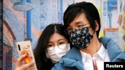 Wang, 32,și soția sa Shi, 30, au purtat măști de protecție la căsătoria lor de la oficiul stării civile, căsătorie care a avut loc de Valentine's Day în Shanghai