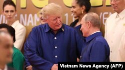 Президент США Дональд Трамп и президент России Владимир Путин (справа) во время обмена рукопожатиями. Дананг, 10 ноября 2017 года.