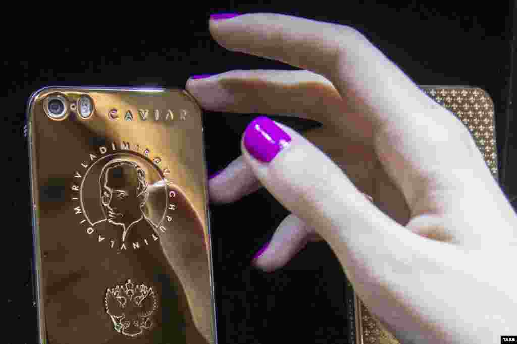 An iPhone with a golden coating, bearing the portrait of Russian President Vladimir Putin and the lyrics of the national anthem, is displayed on sale at the Zhukoffka Plaza shopping center in Moscow. (ITAR-TASS/Mikhail Dzhaparidze)