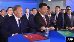 Chinese President Xi Jinping (right) and Kazakh counterpart Nursultan Nazarbaev turn a symbolic lever during an opening ceremony of the new container service between western China and Western Europe in Astana in June.