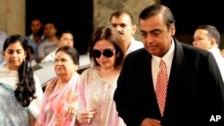 India's corporate giant Reliance Industries Ltd. Chairman Mukesh Ambani, right, accompanied by his wife Nita, second from left, arrives for the company's annual general meeting in Mumbai, India, Friday, June 3, 2011. 