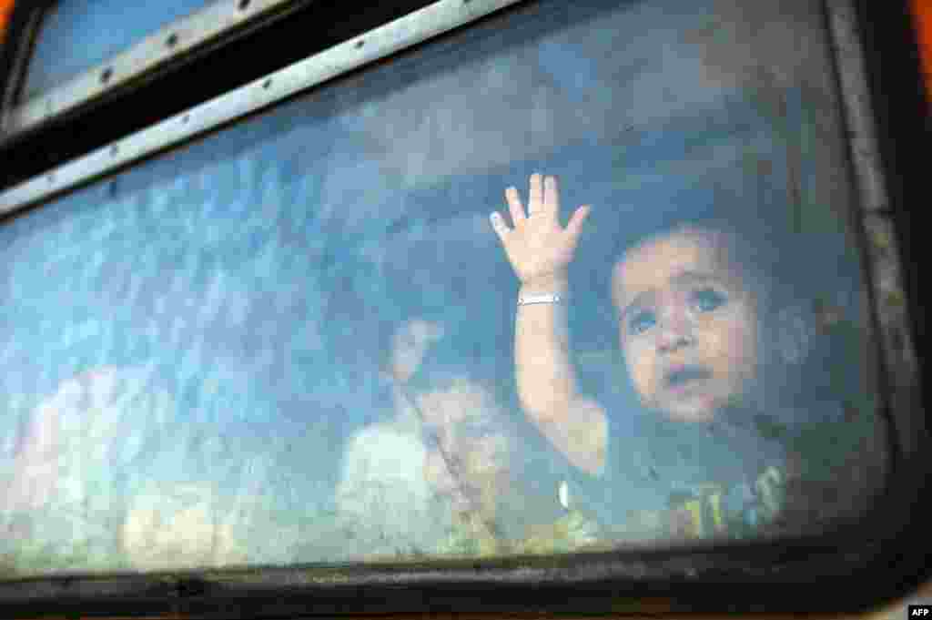 A migrant boy looks through a window onboard a train for Serbia at the new transit center for migrants at the border line between Greece and Macedonia near the town of Gevgelija, Macedonia. (AFP/Robert Atanasovski)