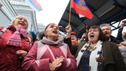 People celebrate the arrival of a passenger train from Russia in the Crimean city of Sevastopol on December 25.