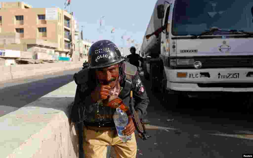 A policeman washes away the effects of tear gas fired by police after Shi'ite Muslim men blocked the main national highway and railway tracks to protest raids of both Sunni and Shi'ite religious seminaries and the detention of an unspecified number of people, in Karachi, Pakistan. (Reuters/Akhtar Soomro)