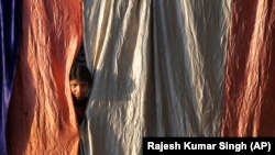 A girl living on the roadside looks out from her makeshift home during a lockdown to control the spread of the coronavirus in Prayagraj, India, on March 25. 