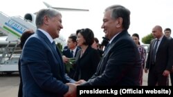 Өзбекстан президенті Шавкат Мирзияев (оң жақта) Қырғызстан президенті Алмазбек Атамбаевты Ташкент әуежайынан күтіп алып тұр. 5 қазан 2017 жыл.