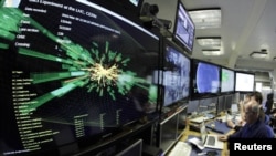 A graphic shows a collision at full power at the Compact Muon Solenoid experience control room of the Large Hadron Collider at the European Organization for Nuclear Research (CERN) in Meyrin.
