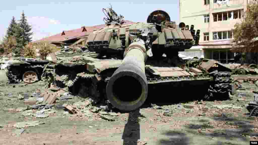 14 августа: уничтоженный грузинский танк среди руин Цхинвали. Российские и грузинские официальные лица договорились о плане прекращения огня 12 августа, который через два дня подписали руководители Южной Осетии и Абхазии