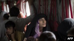 Pakistani flood survivors sit in a U.S. Army helicopter