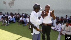 A Libyan rebel argues with a man suspected of being a mercenary for Muammar Qaddafi, in a district sports center next to the medina, set up as provisory jail, in Tripoli, on August 30.