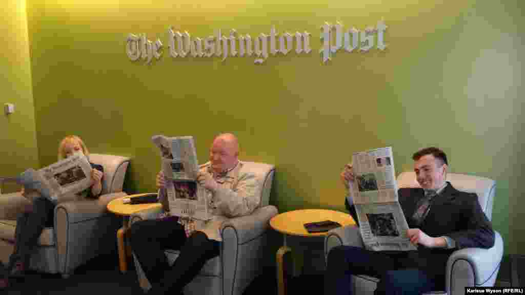 Sedletska (l), Beliaev and Gabidulin during their visit to "The Washington Post," reading the latest edition from top to bottom...