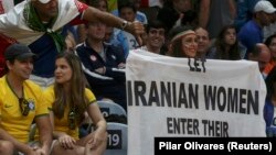 Darya Safai holds a banner reading "Let Iranian women enter their stadiums" at the Iranian men's volleyball match against Egypt on August 13.