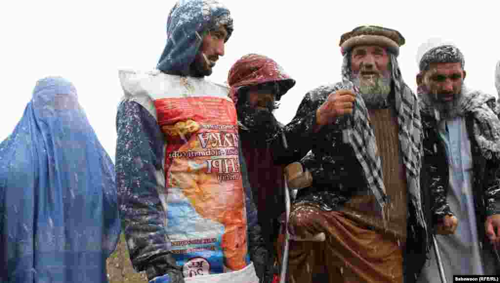 A man wears a food sack as an extra layer of protection against the cold. 