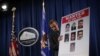 WASHINGTON, DC - MARCH 24: A Department of Justice employee put up a poster of the seven indicted hackers prior to a news conference for announcing a law enforcement action March 2