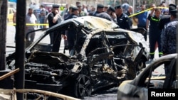 The wreckage of a car is seen at the site of bombing near a government office in Baghdad's Karkh district on May 30.