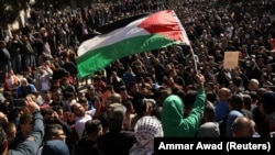 Worshippers wave a Palestinian flag after Friday prayers on the compound known to Muslims as Noble Sanctuary and to Jews as Temple Mount in Jerusalem's Old City, December 8, 2017