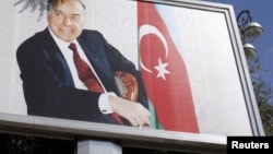 Azerbaijan -- A woman walks past a board displaying late President Haydar Aliyev in Baku, 13Oct2010